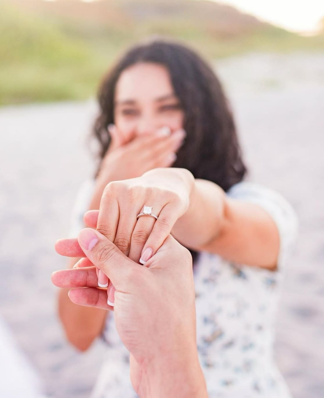 Woman holding hand and has an engagement ring on